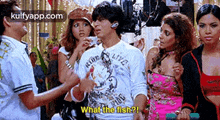 a group of people are standing around a man in a white shirt who is talking to them .