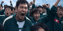 a group of people wearing green uniforms with a red x on the sleeve