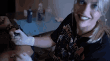 a woman is getting a tattoo on a person 's arm .