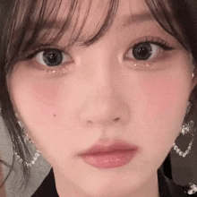 a close up of a woman 's face with a lot of makeup on it .