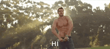 a shirtless man is standing in a park and says hi
