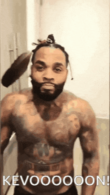 a shirtless man with a beard is standing in front of a mirror with a brush in his hair .