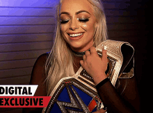 a woman holding a wrestling belt with the words digital exclusive in the corner