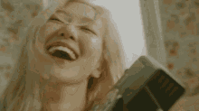 a close up of a woman laughing with a camera .