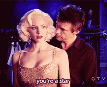 a woman in a gold dress says you 're a star next to a man