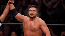 a shirtless wrestler is giving a high five to his opponent