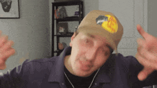 a man wearing a bass pro shops hat is making a funny face