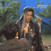 a man with long hair is getting his hair braided