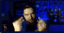 a man in a blue shirt is making a middle finger gesture .