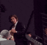 a man in a suit is holding a piece of paper that says ' gd ' on it