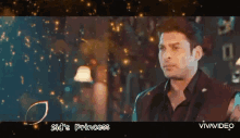 a man in a black suit is standing in front of a blue background with the words sid 's princess written on it