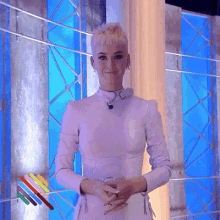 a woman in a white dress is smiling in front of a blue background