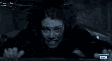 a man in a dark room with an advertisement for a tv show called a.m.c.