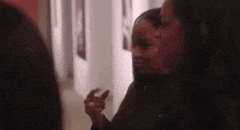 a group of women are standing next to each other in a hallway looking at paintings .