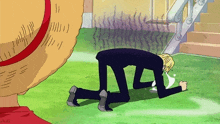 a man in a suit is kneeling on the grass in front of a straw hat and stairs .