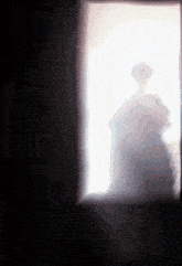 a shadow of a person is cast on a wall in a dark room