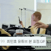 a person sitting at a table with a cup of coffee and a cell phone in their hand