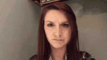 a woman is making a funny face in front of a sign that says but you