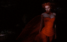 a woman in a pink dress is standing in the dark