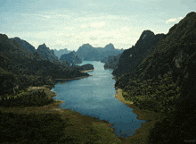 an aerial view of a lake surrounded by mountains and trees