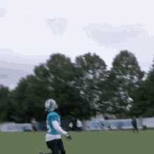 a football player in a blue jersey with the number 20 on it is running on a field .