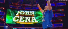 a man is standing in front of a green sign that says john cena