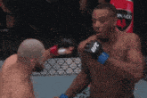 a man wearing a pair of ufc gloves is about to punch another man
