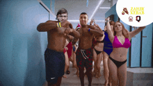 a group of people in swimsuits are dancing in a hallway with a sign that says zahir kebab