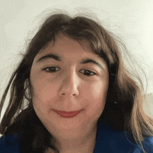 a close up of a girl 's face with a blue shirt