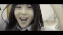 a close up of a woman 's face with her mouth open . she is wearing a tie and smiling .
