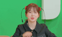 a young woman with pigtails and a bow in her hair is making a funny face .