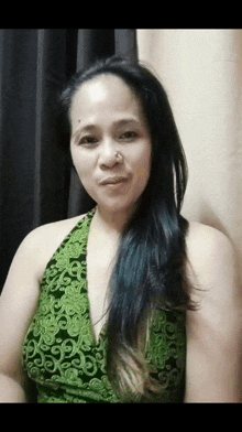 a woman wearing a green top with a nose ring
