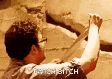 a man is holding a large axe in his hand and says `` patch bitch '' .