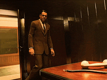 a man in a suit and tie is standing in front of a telephone