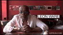 a man sitting at a table with the name leon ware on the bottom