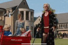 a red radio flyer wagon is pulled by a woman