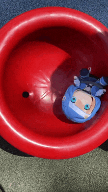 a person in a blue outfit is going down a red bowl
