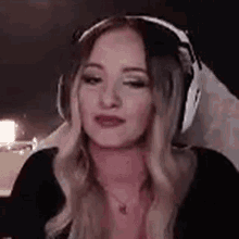a woman wearing headphones and a necklace is making a funny face .
