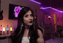 a woman in a room with purple lights and a tv that has the word age on it