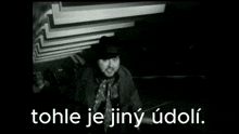 a black and white photo of a man with the words tohle je jiny udoli above him