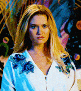 a woman is wearing a white shirt with blue flowers on it