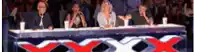 a group of people are sitting at a table in front of a sign that says xxx