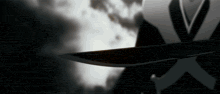 a man in a suit is holding a knife in his hand .