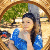 a woman in a blue dress is looking at herself in a mirror
