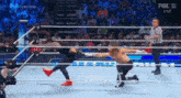 a man is kneeling down in a wrestling ring while another man is standing in the ring .