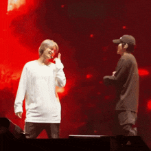 two men standing on a stage with one wearing a white shirt that says ' reebok ' on it