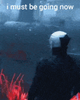 a man in a white helmet stands in a dark room with the words " i must be going now " written above him