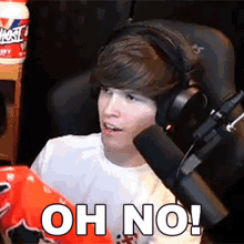 a young man wearing headphones is holding a bag of chips and says " oh no "
