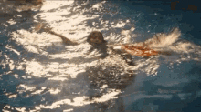 a woman is swimming in a pool with her arms outstretched .