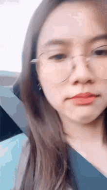 a close up of a woman wearing glasses and a seat belt in a car .